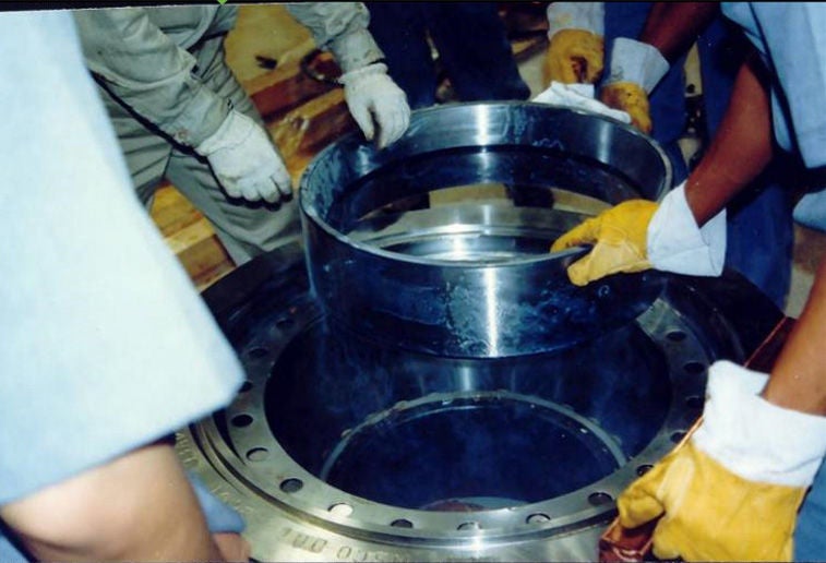 Workers performing a cool (freeze) fit after material is cooled and shrinks.
