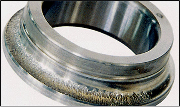 Actual spalling (flaking) on the inner ring raceway surface of a bearing. The normally smooth surface appears rough around the entire circumference of the ring. 